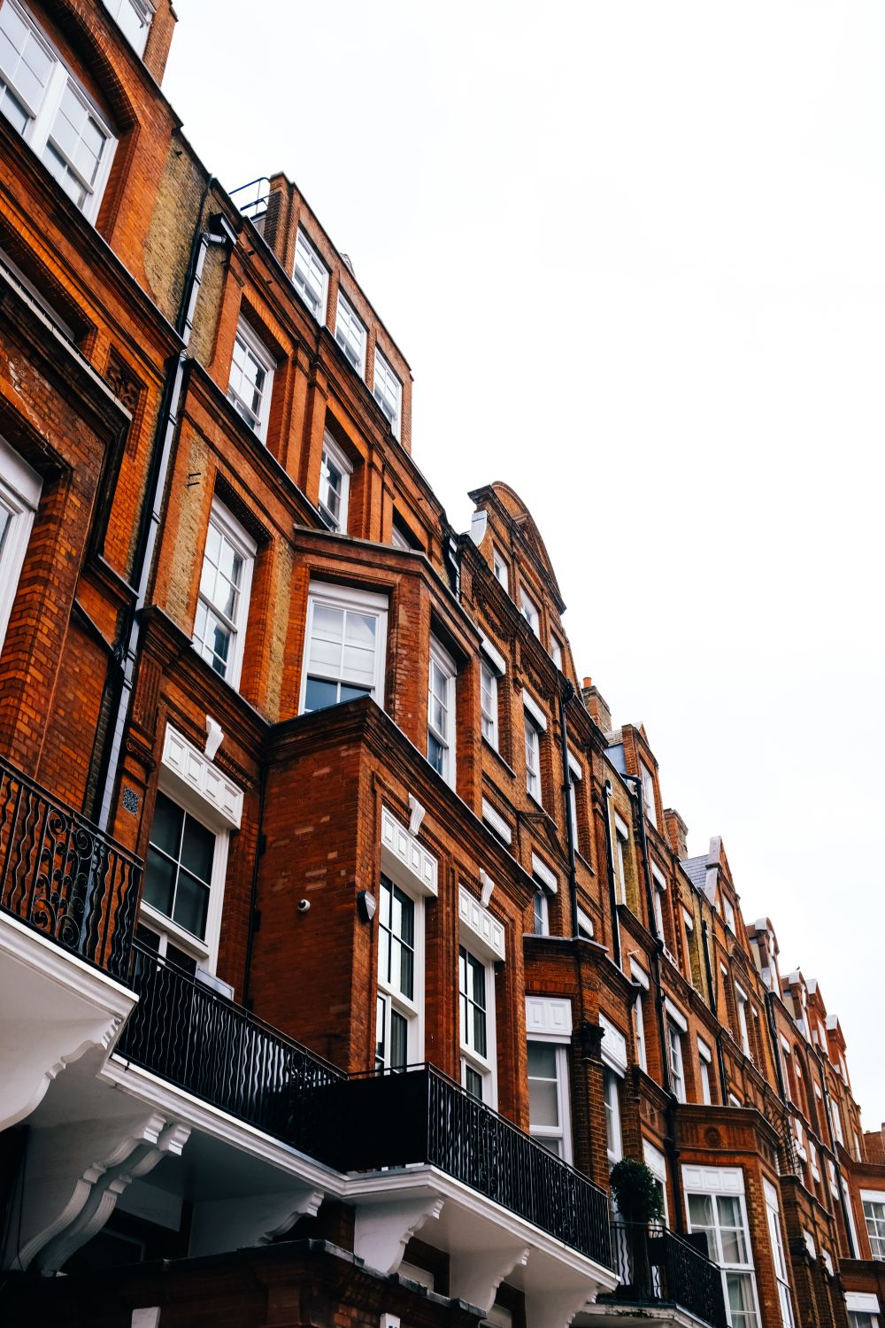 A row of London brick terraced houses with sash windows.